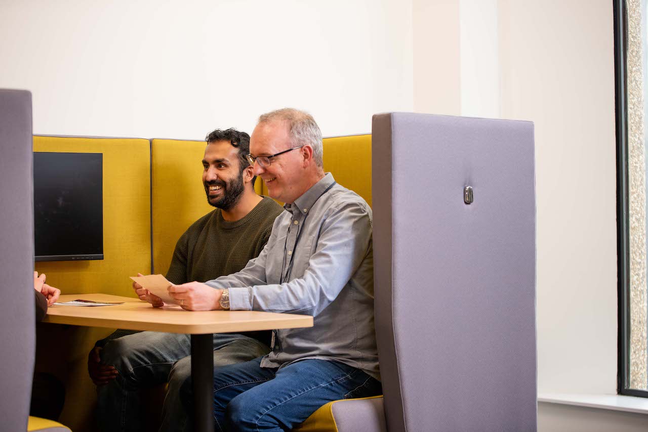 Two men in a meeting at work laughing